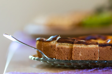 Käsekuchen auf einem Glasteller mit Kuchenheber