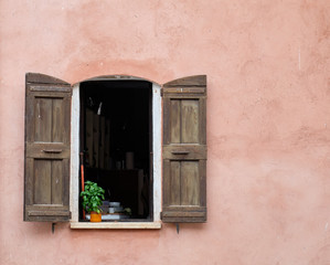 Window with shutters and potted basil plant in Roussillon, France