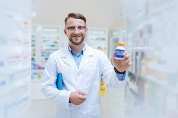 Fototapeta premium Positive delighted young chemist showing favorite probiotics