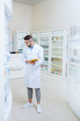 Serious stylish pharmacist looking for necessary medicine