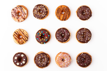 Yummy chocolate glazed assorted doughnuts on white background.Top view.