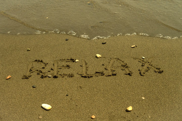 Word Relax written at sandy beach