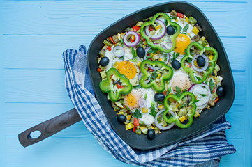 Fried eggs with vegetables in a pan. Shakshuk. Arabic cuisine Proper nutrition. View from above. Space for text.