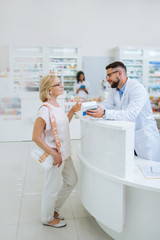 Pretty blonde female person talking to pharmacist
