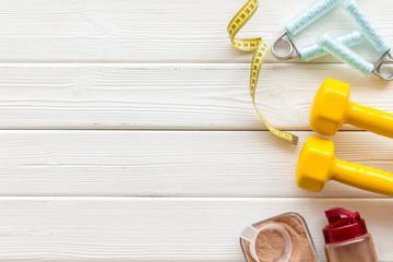 protein powder for fitness nutrition, bars, measuring tape on white wooden background top view mock up