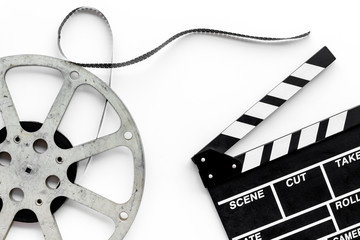 Filmmaker profession with clapperboard and video tape on white background top view