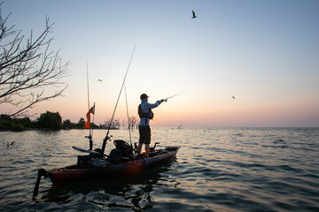 Young Man Kayak Fishing at Sunrise in Canada