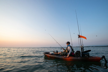 Young Man Kayak Fishing at Sunrise in Canada