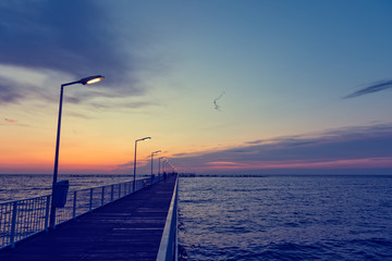 Obraz premium Vintage look of a pontoon bridge with light poles over Black Sea in the early morning hours before sunrise