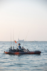 Obraz premium Young Man Kayak Fishing at Sunrise in Canada