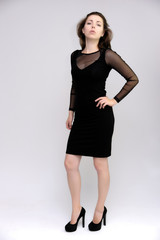 Horizontal Portrait of a pretty slim beautiful fashionable adult girl with beautiful brunette hair in a black dress. It should be in full growth, talking showing different poses and emotions