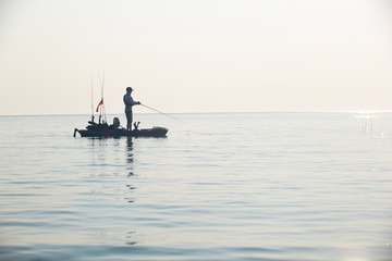 Naklejka premium Young Man Kayak Fishing at Sunrise in Canada