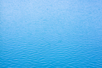 Blue rippled water as abstract background. Tranquil surface texture of the sea. Water ripples of a lake. Blue sea water in calm.