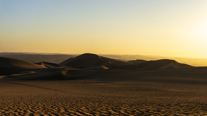 Atardecer en el desierto con tonos naranjas y azules