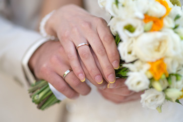 Obraz na płótnie Canvas The bride and groom's hands with rings