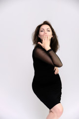 Horizontal Portrait of a pretty slim beautiful fashionable adult girl with beautiful brunette hair in a black dress. It should be in full growth, talking showing different poses and emotions