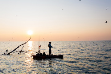 Fototapeta premium Young Man Kayak Fishing at Sunrise in Canada
