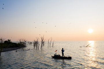 Fototapeta premium Young Man Kayak Fishing at Sunrise in Canada