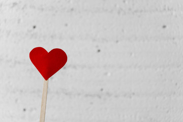 Paper red heart that sympholise love and passion on the left on a white blurred background....