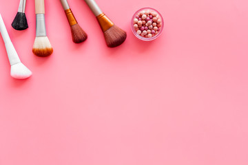 Obraz na płótnie Canvas Brushes for make up, blusher on pink visagiste work desk background top view copyspace
