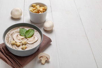 Mushroom cream soup on rustic white wooden table