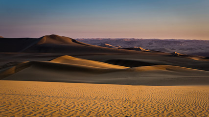 Fototapeta na wymiar Sol iluminando las dunas y el desierto al atardecer