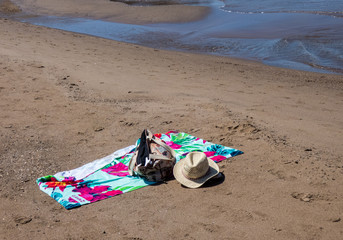 Empty beach in Costa Calida , hat, a beach bag, and a towel lie on the beach