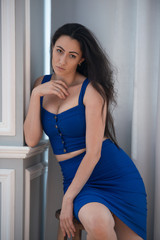 Office romance in the workplace. Seductive businesswoman secretary in blue dress sitting on a...