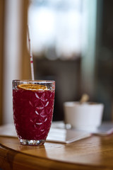 Glass with red cocktail and plastic straw