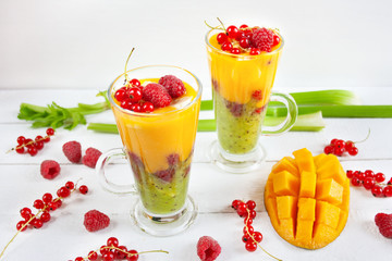 A multi-layered smoothie with mango, kiwi, celery, currants and raspberries