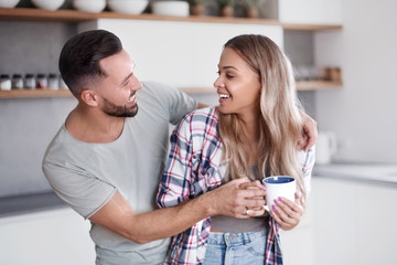 happy young couple in kitchen in good morning time