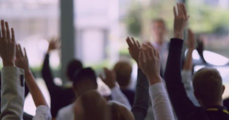 Business professionals raising their hands in a business seminar 4k