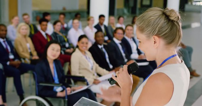female speaker speaks in a business seminar at modern office 4k