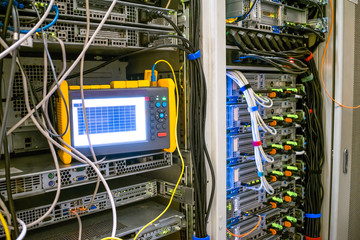 Measurement of the signal level with an optical reflectometer. Diagnostics of telecommunication problems in the server room of the data center. Many internet cables are in racks