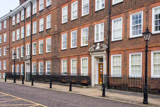 Classic historical apartments Building in Georgian British English style with white windows and red brick wall in central London