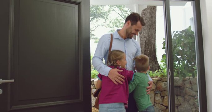 Father embracing his children at door in a comfortable home 4k
