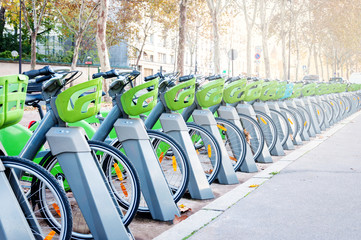 Parking with a large number of electric bikes for renting and driving around the city. Autumn sunny...