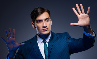 Businessman pressing virtual buttons on gray background