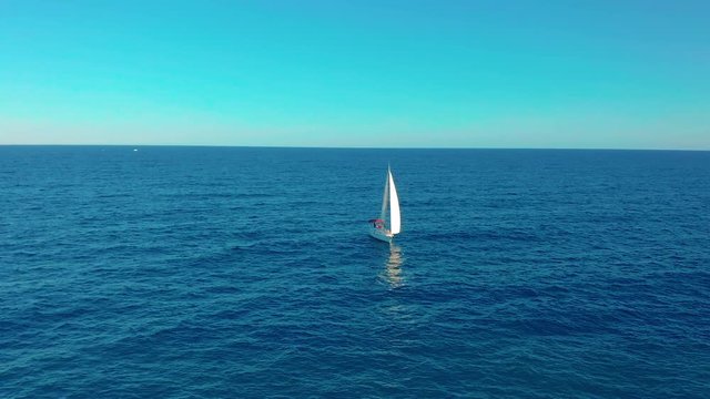Aerial view. Yacht sailing on open sea at sunny day.