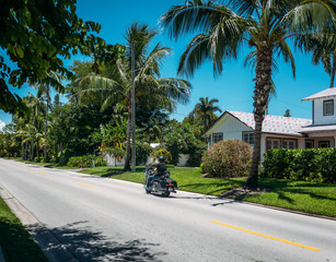  Motorcycle driving through the street at vocation city with palms