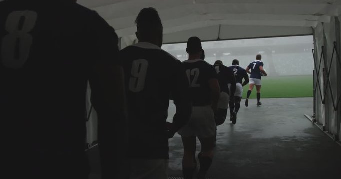 Male rugby players running together in a row at the entrance of stadium 4k