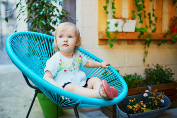 Adorable toddler girl sitting in fancy chair