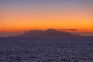 Beautiful sunset with orange sky with Aegean Sea island background