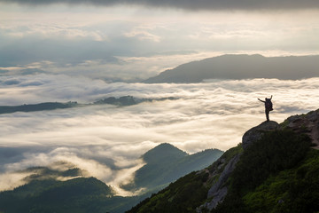 Wide mountain panorama. Small silhouette of tourist with backpack on rocky mountain slope with...