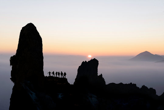 professional climbers watching the sun at the summit and achievements