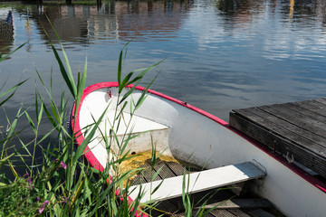 rowing boat between grass in water. Broek op Langedijk, The Netherlands © Corinne