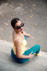 Young woman wearing sunglasses and denim pants outdoors