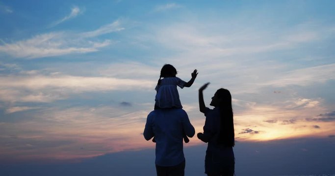 Silhouettes of asian kids riding on neck and shoulder of father on the beach summer together in holiday. Concept of family, travel, silhouettes and relationship. 4k resolution.