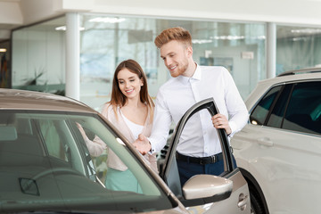 Woman choosing new car in salon