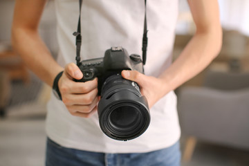 Teenage boy with photo camera at home, closeup